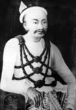 Mindon Min (8 July 1808 – 1 October 1878) was the penultimate king of Burma (Myanmar) from 1853 to 1878. He was one of the most popular and revered kings of Burma. Under his half brother King Pagan, the Second Anglo-Burmese War in 1852 ended with the annexation of Lower Burma by the British Empire. Mindon and his younger brother Kanaung overthrew their half brother King Pagan. He spent most of his reign trying to defend the upper portion of his country from British encroachments, and to modernize his kingdom.<br/><br/>

King Mindon founded the last royal capital of Burma, Mandalay, in 1857. His young brother Kanaung proved to be a great administrator and modernizer. During Mindon's reign, scholars were sent to France, Italy, the United States, and Great Britain, in order to learn about the tremendous progress achieved by the Industrial Revolution.<br/><br/>

Mindon introduced the first machine-struck coins to Burma, and in 1871 also held the Fifth Buddhist council in Mandalay. He had already created the world's largest book in 1868, the Tipitaka, 729 pages of the Buddhist Pali Canon inscribed in marble and each stone slab housed in a small stupa at the Kuthodaw Pagoda at the foot of Mandalay Hill.